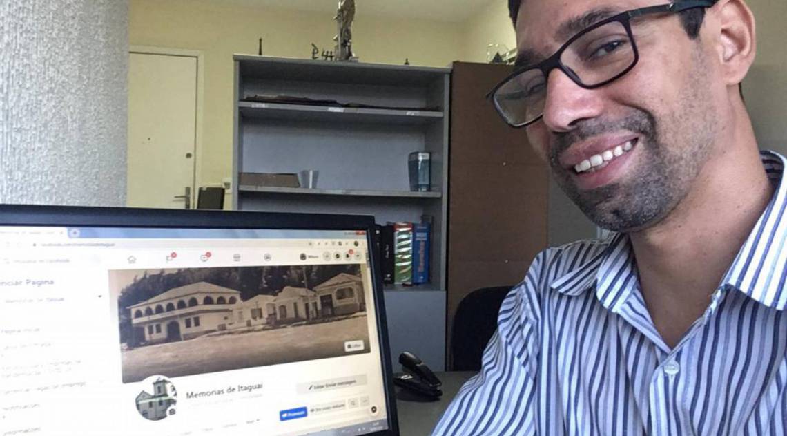 Wilson Santiago, em casa, com a página Memórias de Itaguaí aberta no computador: imagens para preservar vivos os registros históricos da região - Arquivo pessoal