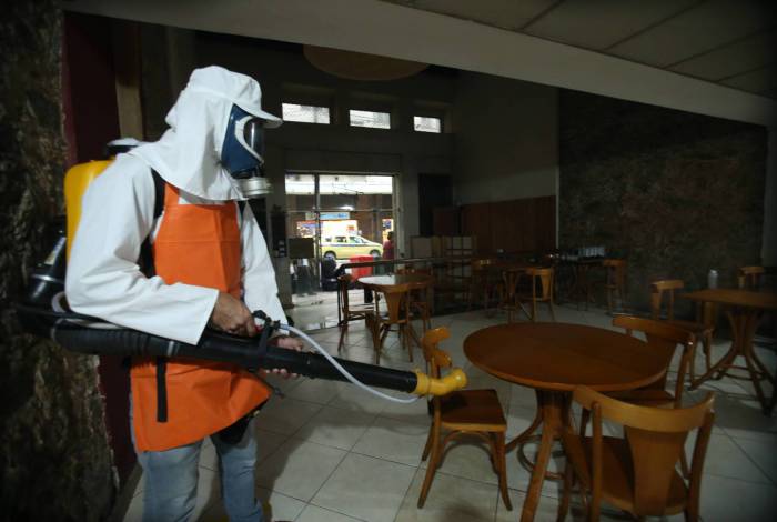 Funcionário higieniza restaurante, no Centro, na véspera de reabrir as portas e receber clientes