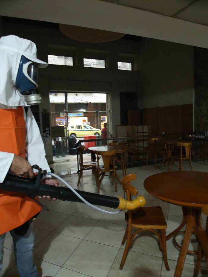 Funcionário higieniza restaurante, no Centro, na véspera de reabrir as portas e receber clientes