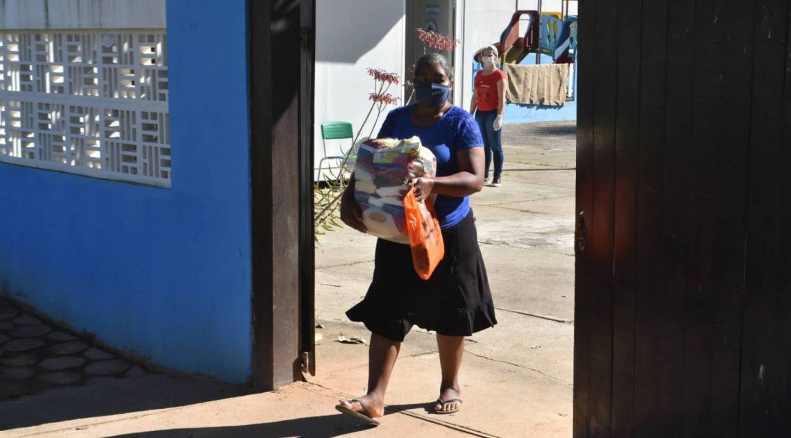 Responsáveis precisam usar máscaras, conforme determina decreto municipal, para buscar kits de gêneros alimentícios