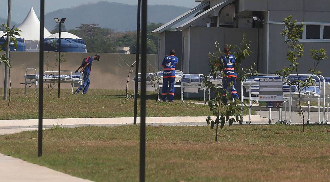Equipe retira macas em Nova Iguacu. Em Caxias, empresários (destaque) dizem não terem sido pagos - Fotos de Cléber Mendes