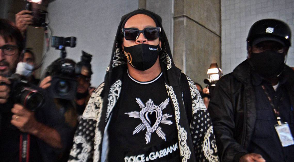 Former football star Ronaldinho (C) is pictured upon arriving on a private jet at El Galeao airport in Rio de Janeiro, Brazil, on August 25, 2020, following more than five months in detention in Paraguay over a fake passport scandal. - A judge on Monday released Ronaldinho, 40, and his brother, who had both been held for a month in jail and another four months under house arrest in a hotel in Asuncion.  - Carl DE SOUZA / AFP