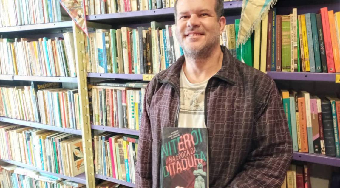Anderson Madeira de Carvalho e sua obra, 'Niterói na época da ditadura', que serve de roteiro para a visita online - DivulgaÃ§Ã£o / Ivan Serrante