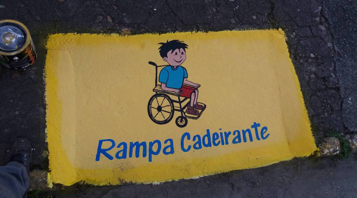 Mensagem em tampa de bueiro alerta para rampa de cadeirantes
