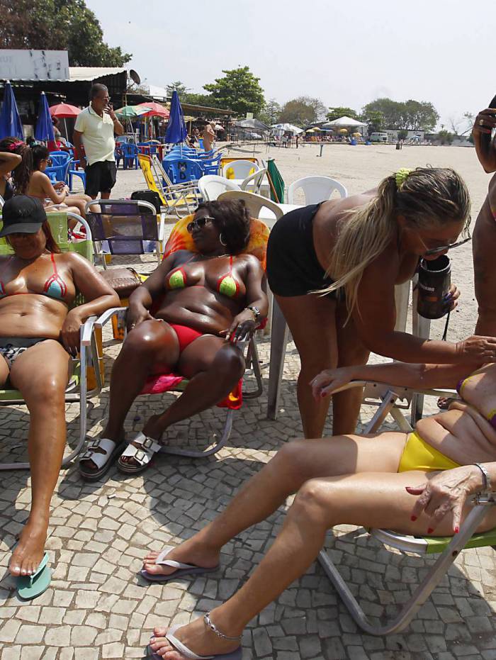 Lilian Ribeiro, a Loira do Bronze, atende às clientes do bronzeamento com fita no Piscinão de Ramos
