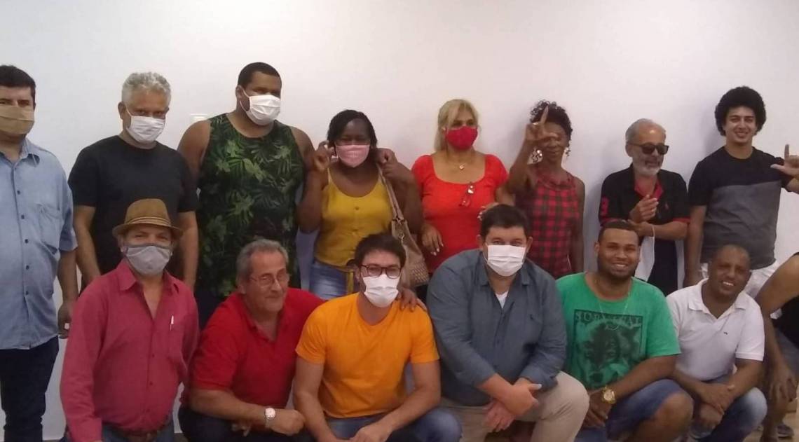 Luciano, abaixado, de camisa laranja. Do seu lado direito, o presidente do PT de Itaguaí, Marcos Garcia; do seu lado esquerdo, Marcus Skurti, presidente municipal do PCdoB - Divulgação - PT Itaguaí