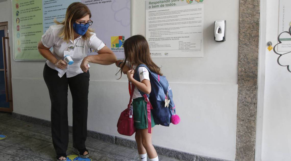 A pequena Marina, sete, &eacute; recebida na entrada da escola