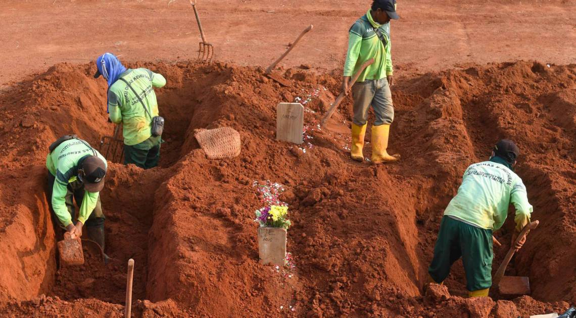 Pessoas são obrigadas a cavar túmulos por desrespeitarem uso de máscara em locais públicos - AFP