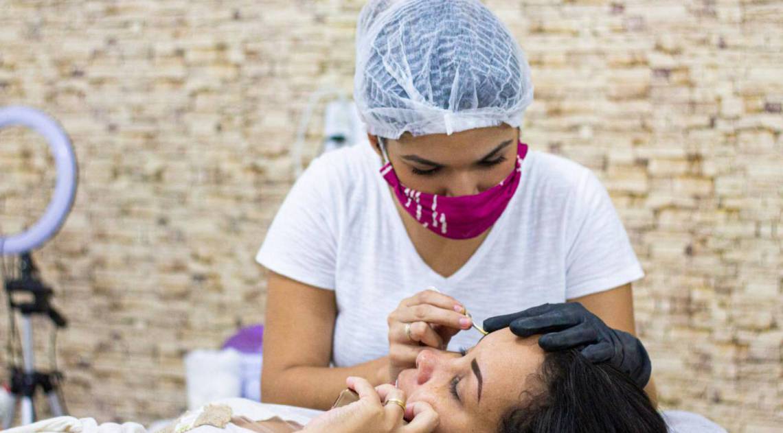 Esteticista Caroline Oliveira realizando procedimento de Design de Sobrancelhas