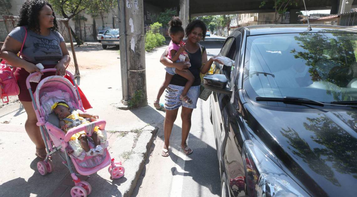 Rio,27/09/2020 -COVID-19 -CORONAVIRUS,ENGENHO DE DENTRO, cariocas celebram o Dia de São Cosme e Damião. Mesmo em tempos de pandemia, a tradição resiste. Os fiéis prestaram sua homenagem aos santos na Paróquia São Cosme e Damião. Na foto, pessoas pegando saquinho de doces.Foto: Cleber Mendes/Agência O Dia