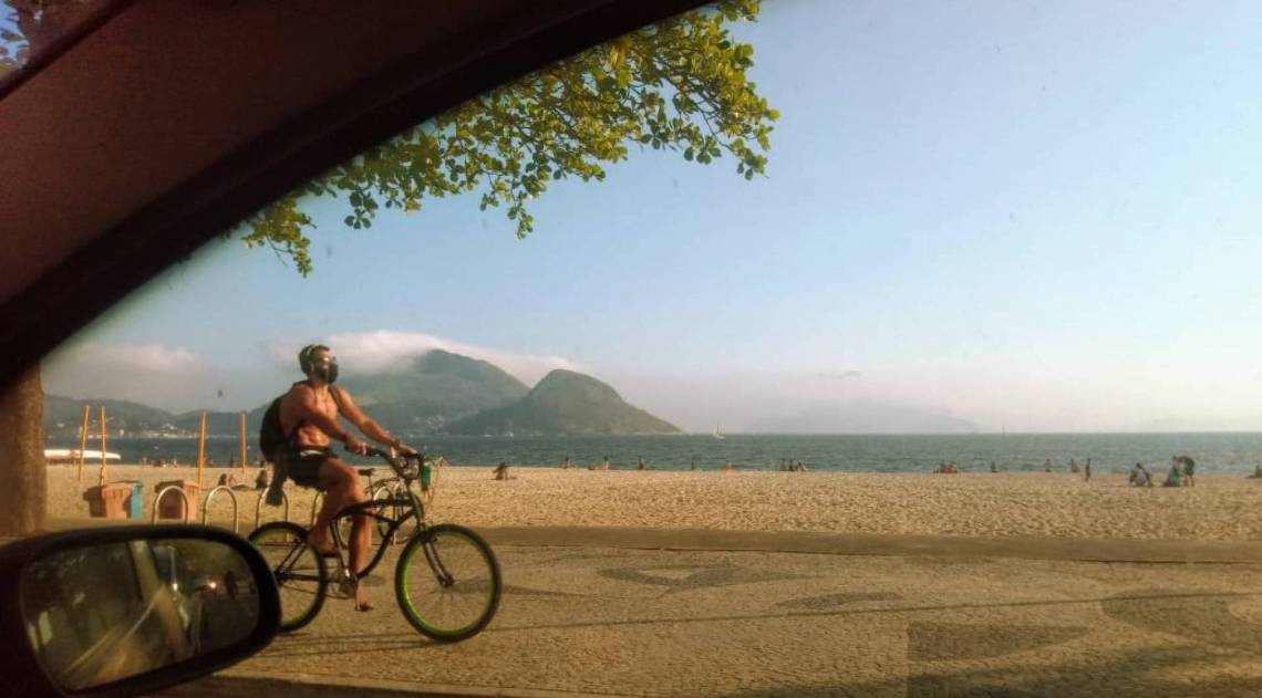 Praia de Icara&iacute;, em Niter&oacute;i, imagem do ciclista de m&aacute;scara resume os tempos atuais. Ana Carla Gomes
