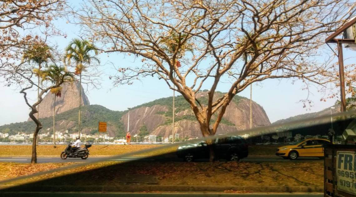 Pelo vidro traseiro do carro de aplicativo, em tempos sem ar-condicionado ligado, a vista do P&atilde;o de A&ccedil;&uacute;car &eacute; clicada 