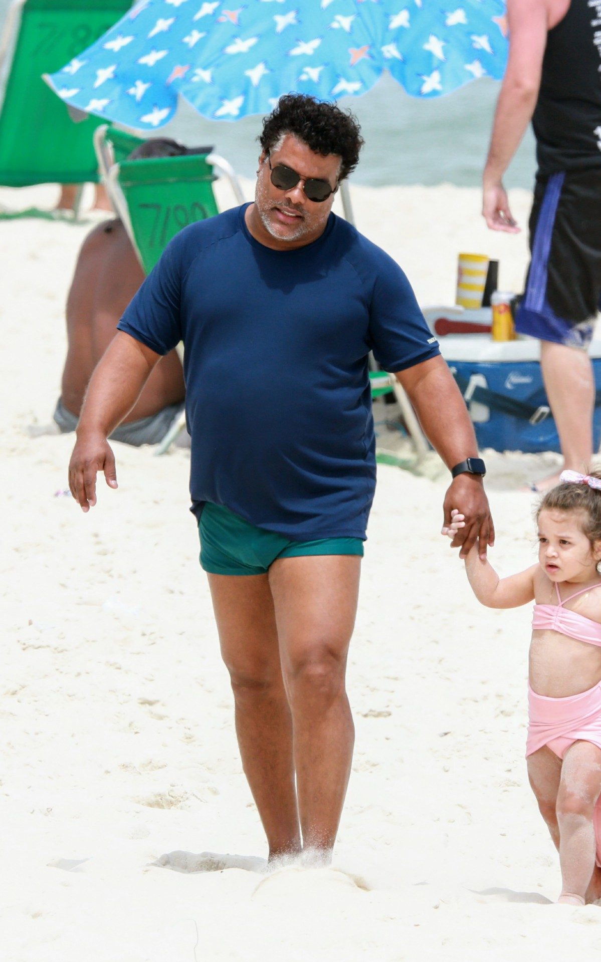 Roberto de Assis brinca com a filha na praia