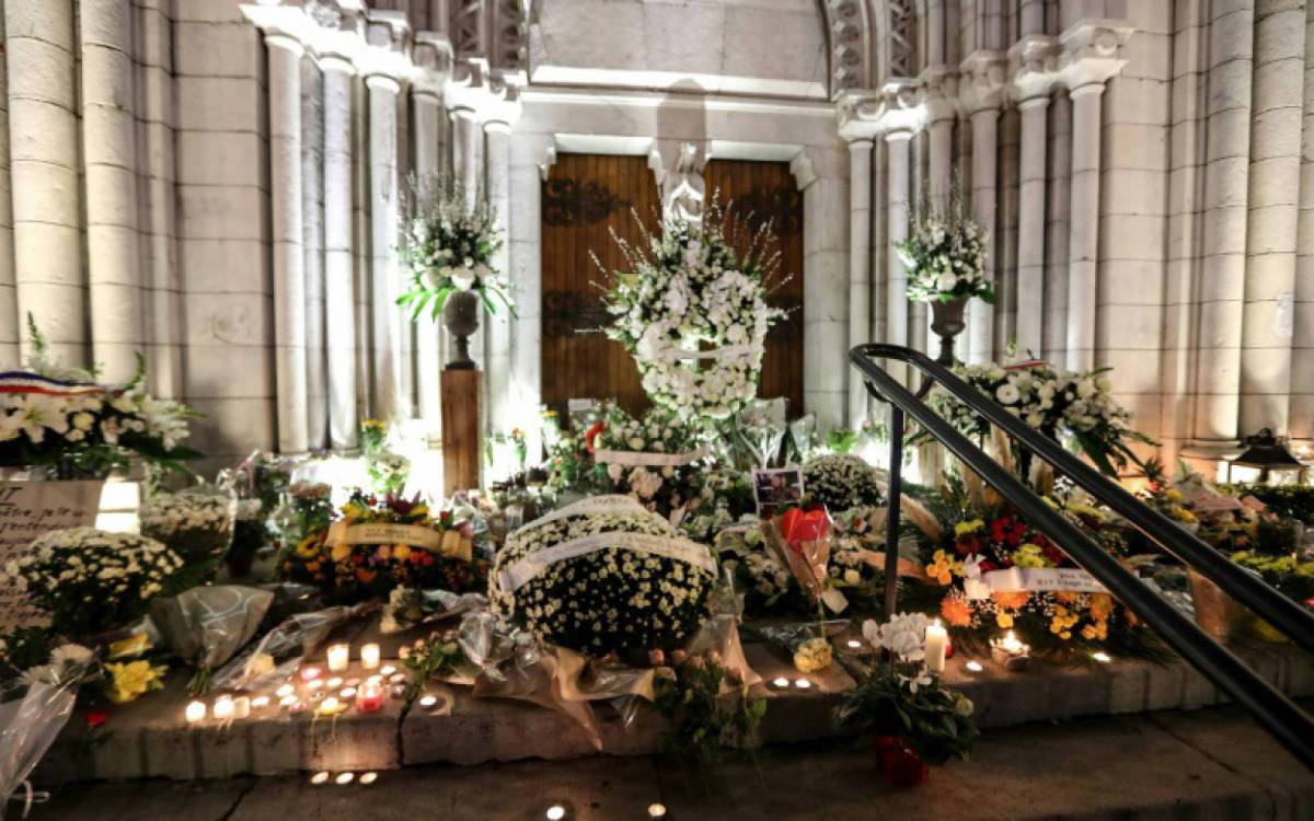 Flores e velas colocadas na escadaria da Igreja Notre-Dame de Nice - AFP