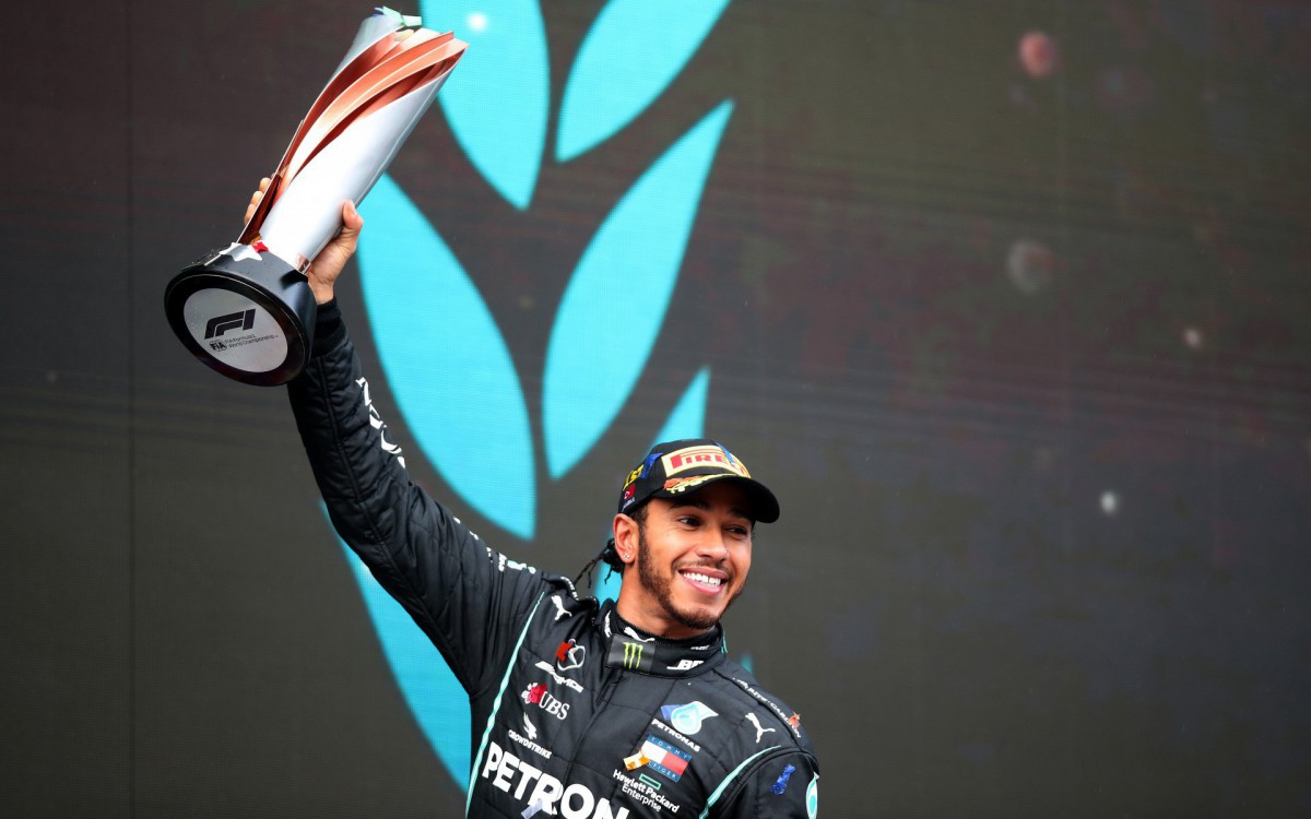 Winner Mercedes' British driver Lewis Hamilton celebrates on the podium after the Turkish Formula One Grand Prix at the Intercity Istanbul Park circuit in Istanbul on November 15, 2020. (Photo by TOLGA BOZOGLU / POOL / AFP) - AFP