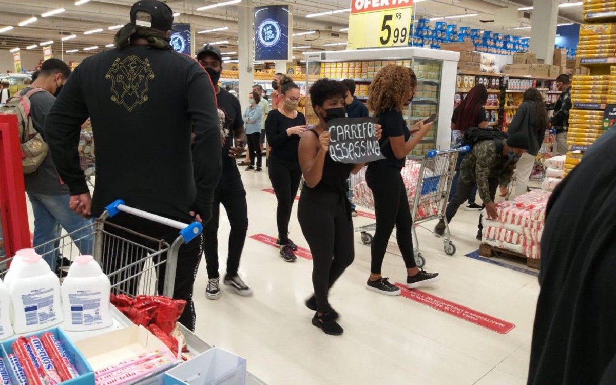 Mulher segura cartaz escrito 'Carrefour assassino'