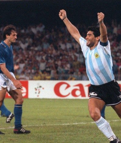 (FILES) In this file photo taken on July 03, 1990 Argentinian forward Diego Maradona (R) celebrates after teammate Claudio Caniggia (not pictured) tied the score at 1 during the World Cup semifinal soccer match between Italy and Argentina in Naples. - Argentinian football legend Diego Maradona passed away on November 25, 2020. (Photo by DANIEL GARCIA / AFP) - DANIEL GARCIA / AFP