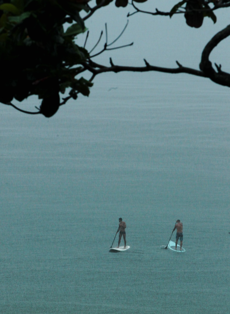 Banhistas no mar durante chuva no Rio