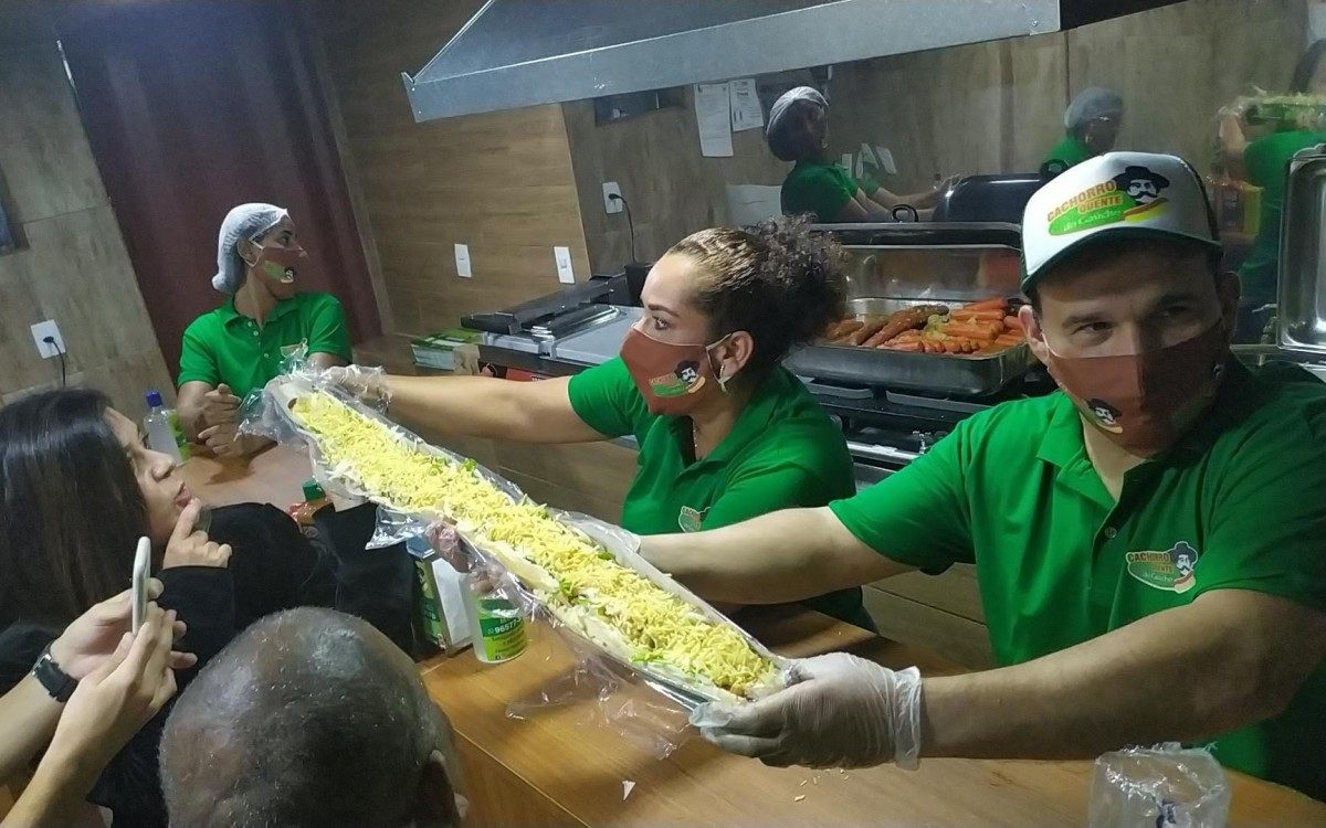 Funcionários seguram o 'Cachorrão de 1 metro'