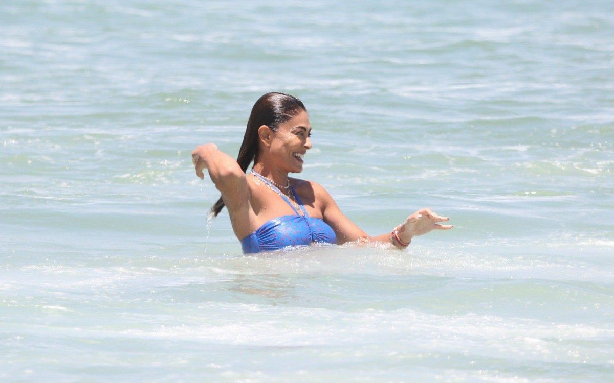 Juliana Paes leva seus filhos para aula de surf na praia
