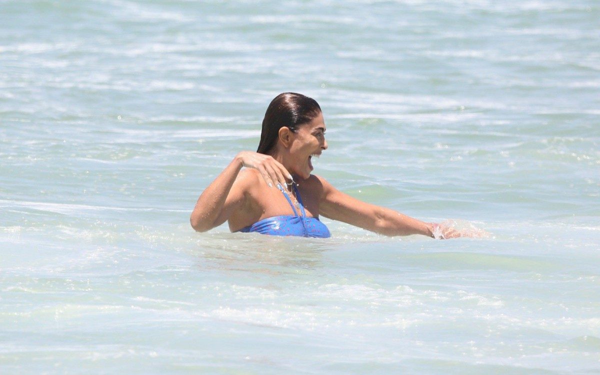 Juliana Paes leva seus filhos para aula de surf na praia