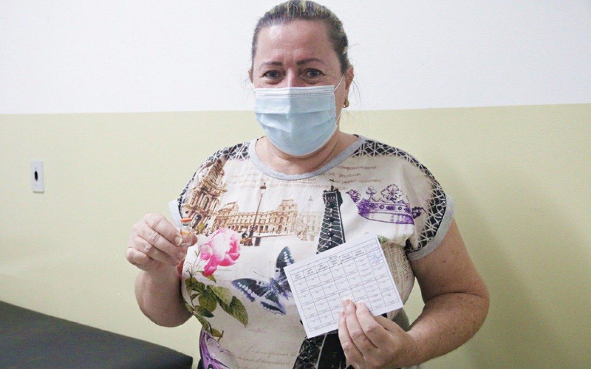 Ao lado do cartão de vacinação, Márcia vai guardar de recordação o frasco da Coronavac