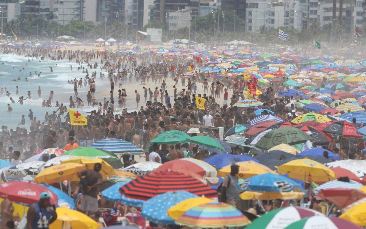 Arpoador e Ipanema - Praias da Zona Sul cheias com grande movimentação de pessoas no calçadão e areia.