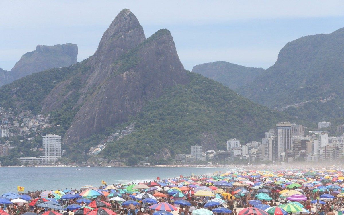 Arpoador e Ipanema - Praias da Zona Sul cheias com grande movimentação de pessoas no calçadão e areia.