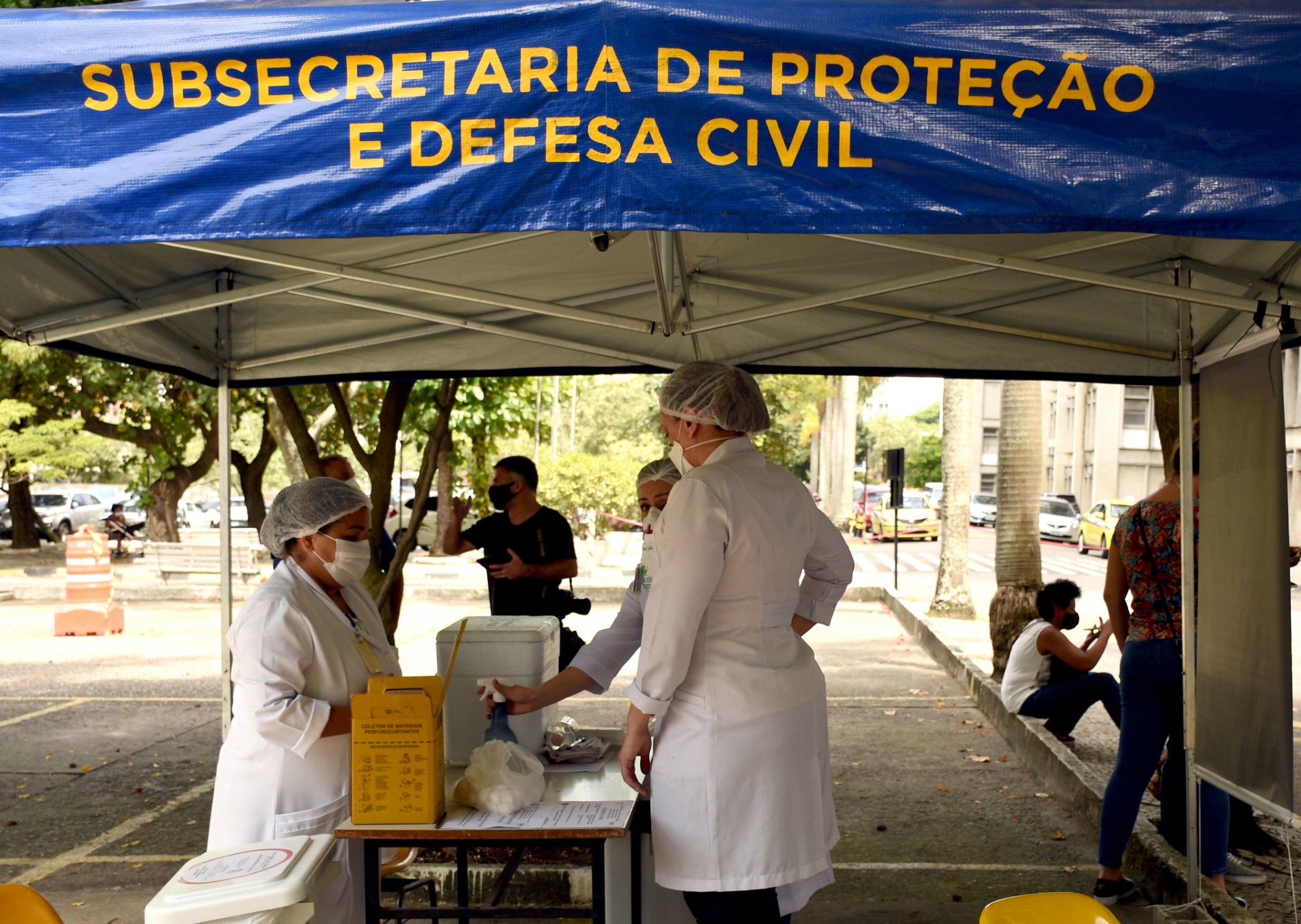 Profissionais abaixo de estande de vacina&ccedil;&atilde;o, em estacionamento, na Uerj - Carlos Magno