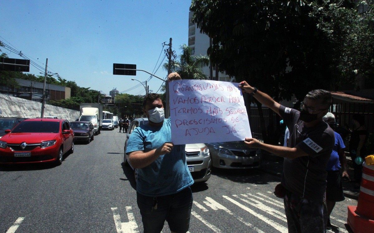 Motorista segurando cartaz em manifestação após morte de colega