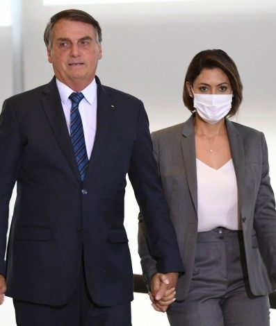 Brazilian President Jair Bolsonaro (L) and first lady Michelle Bolsonaro (R) arrive to the launch of a program to help new mayors at Planalto Palace in Brasilia, on February 23,  2021. (Photo by EVARISTO SA / AFP)
      Caption - AFP