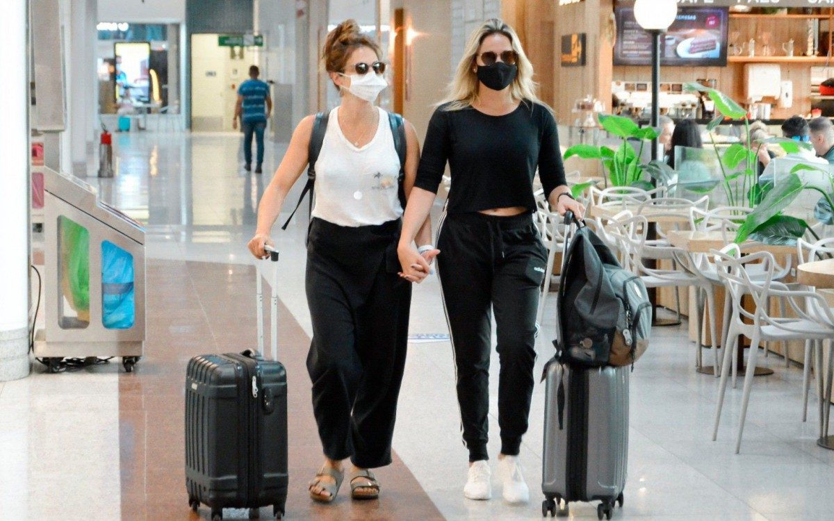 Fernanda Gentil e Priscila Montandon circulam de mãos dadas pelo aeroporto Santos Dumont, no Rio