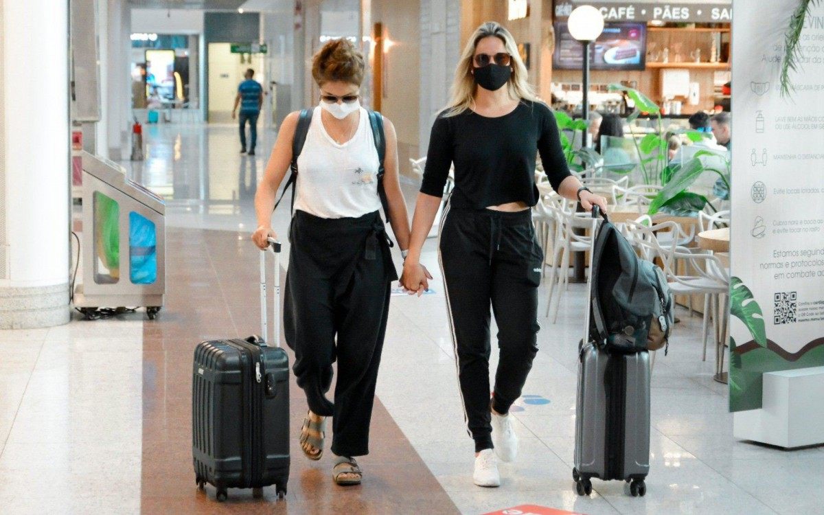 Fernanda Gentil e Priscila Montandon circulam de mãos dadas pelo aeroporto Santos Dumont, no Rio