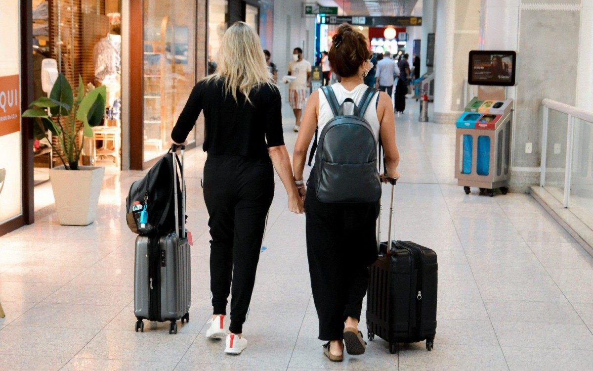 Fernanda Gentil e Priscila Montandon circulam de mãos dadas pelo aeroporto Santos Dumont, no Rio