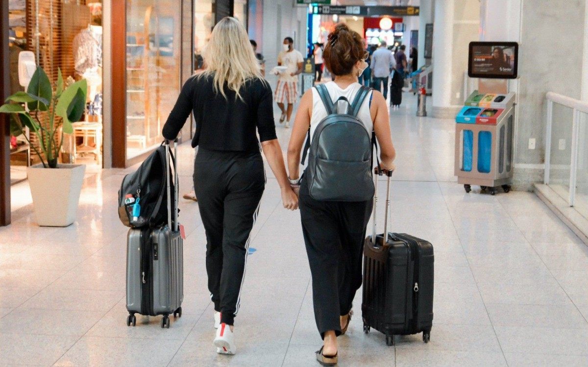 Fernanda Gentil e Priscila Montandon circulam de mãos dadas pelo aeroporto Santos Dumont, no Rio