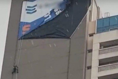 Homem fica pendurado em fachada de prédio no meio de temporal de granizo