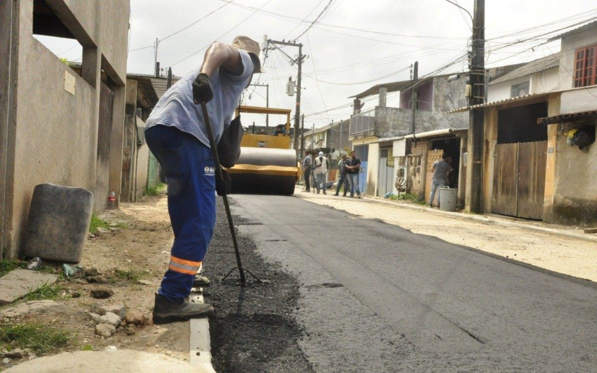 Ap&oacute;s d&eacute;cadas de espera, moradores comemoram, com direito a bolo, a chegada do asfalto em mais uma rua do bairro