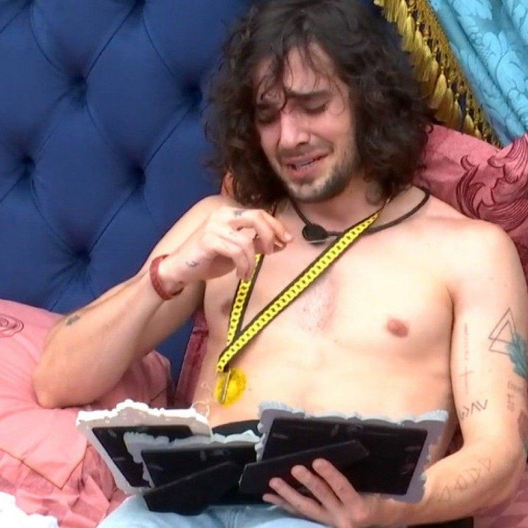 Fiuk chora sozinho enquanto olha para fotos da fam&iacute;lia