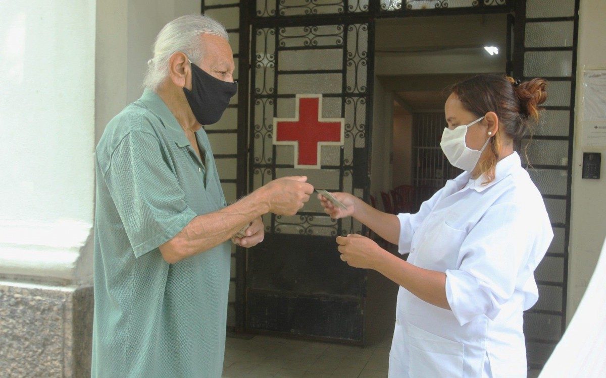 Segunda dose de vacina&ccedil;&atilde;o. Na foto, profissional de sa&uacute;de confere a idade de senhor que foi se vacinar na Cruz Vermelha, no Centro.