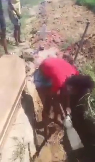 Vídeo: Por falta de coveiro em cemitério, filhos cavam buraco para enterrar a mãe em Magé
