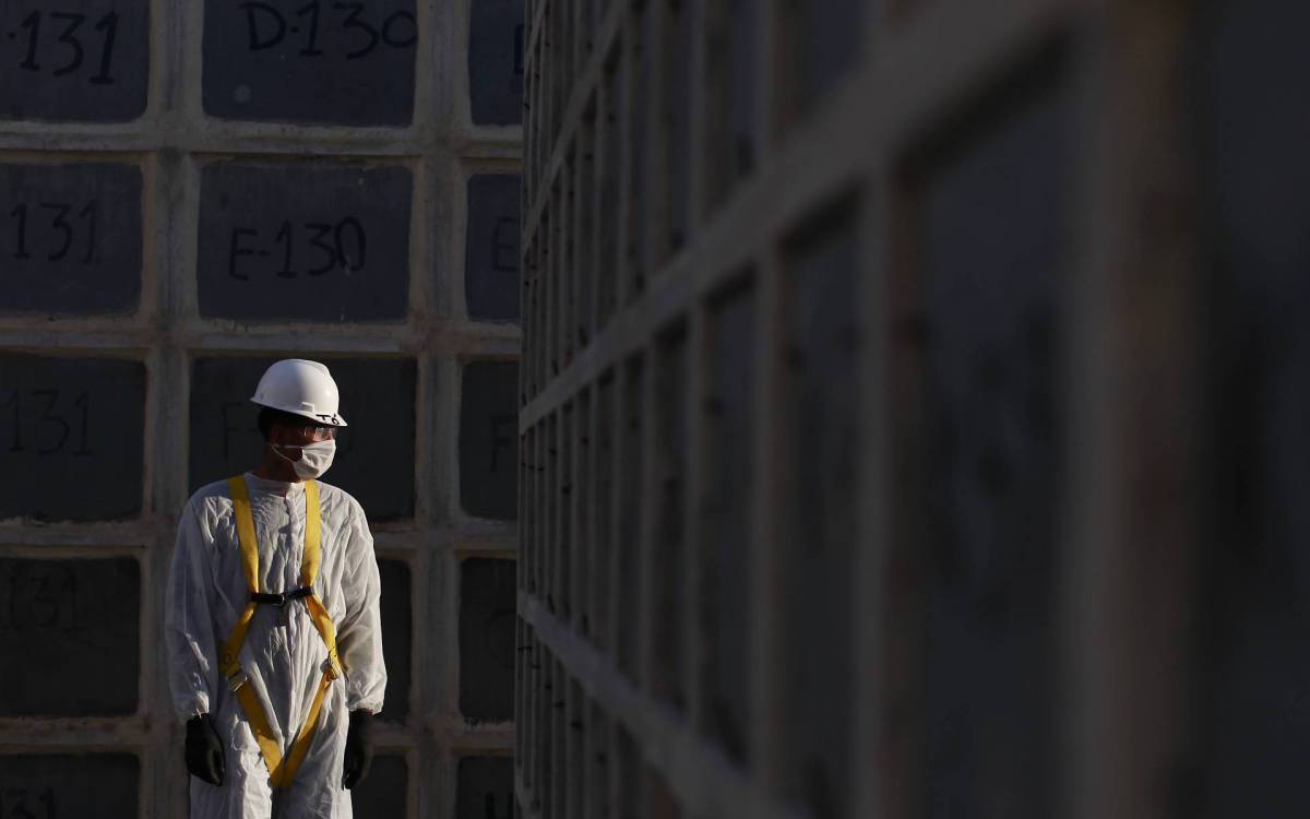 Rio de Janeiro 24/03/2021 - Brasil ultrapassa as 300 mil mortes por Covid-19. Na foto acima o coveiro Washington dos Santos da Silva no cemit&eacute;rio de Inha&uacute;ma. Foto: Luciano Belford/Agencia O Dia