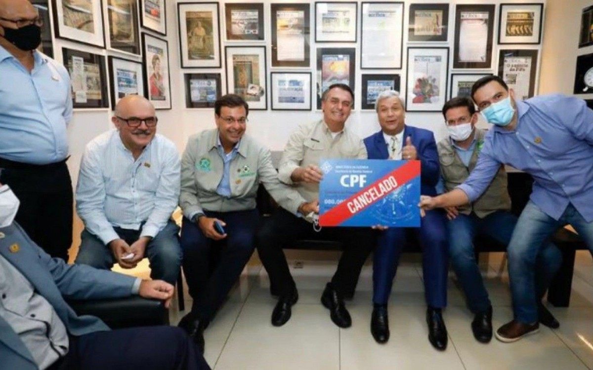 Bolsonaro posa com placa 'CPF cancelado' e é criticado por parlamentares
