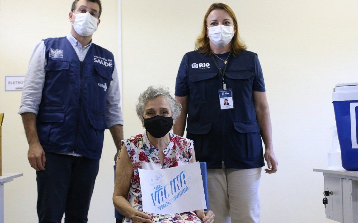 Olivia Assunção tomou a primeira dose da vacina contra covid-19 segurando uma placa defendendo a vacinação  - Daniel Castelo Branco 