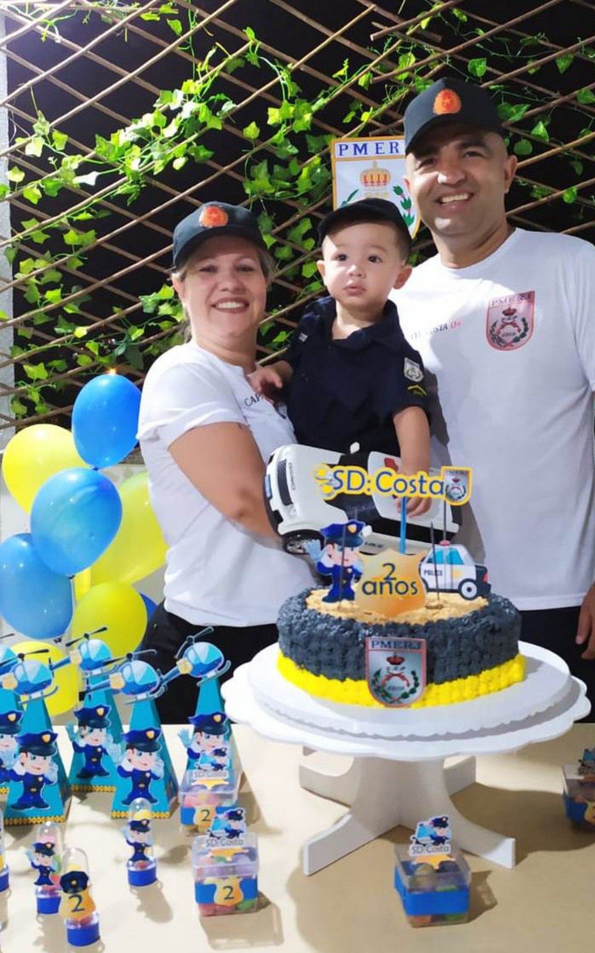 Ano passado, a fot&oacute;grafa Ju Basilio e o radialista Jeronimo Gomes posaram pra foto com o filho Antonio, que &eacute; f&atilde; da PMERJ. 