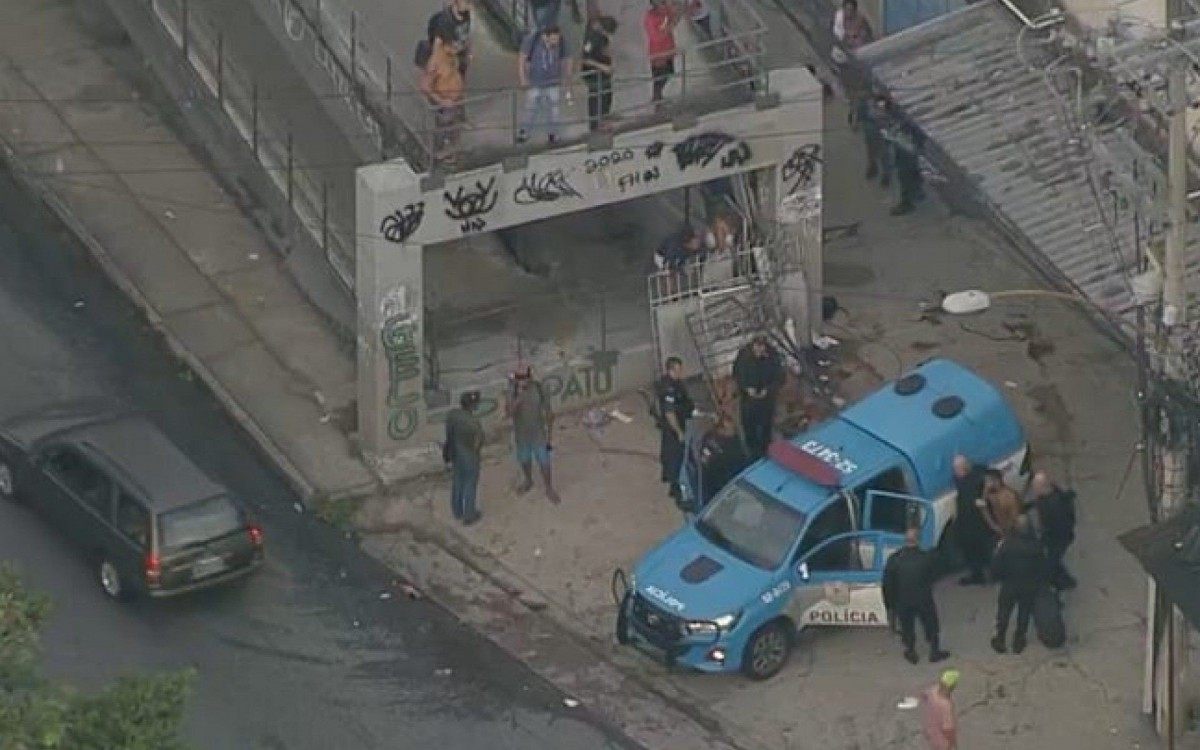 Policiais militares socorrem baleados em passarela da movimentada Avenida Martin Luther King, na altura do Morro do Juramento