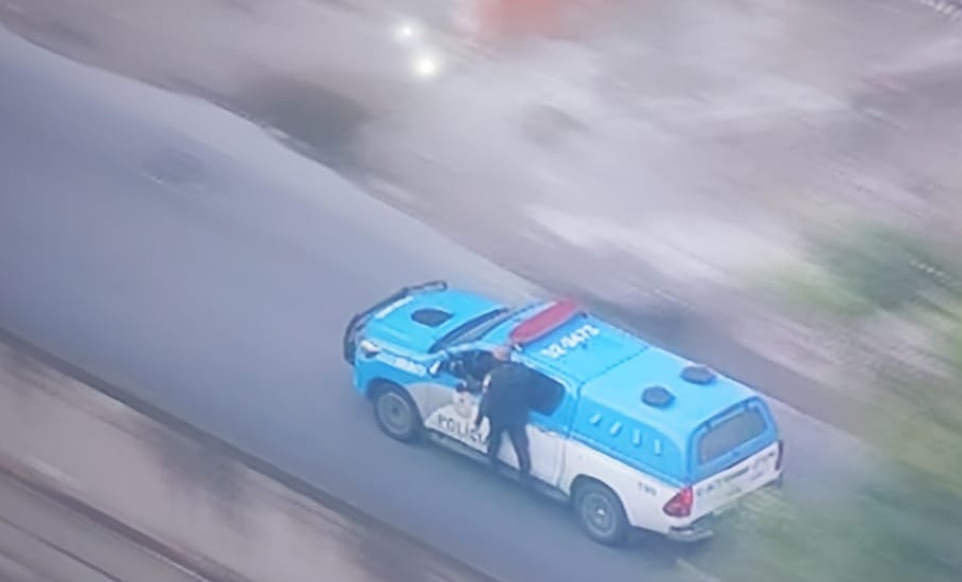 Policial é transportado do lado de fora da viatura durante socorro a feridos em confronto no Morro do Juramento, na Zona Norte do Rio - Reprodução/ TV Globo