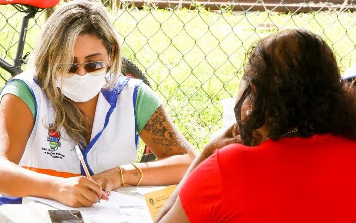 Feirante (de vermelho) atualiza seu cadastro na barraca montada pela prefeitura na feira no &uacute;ltimo domingo (2)