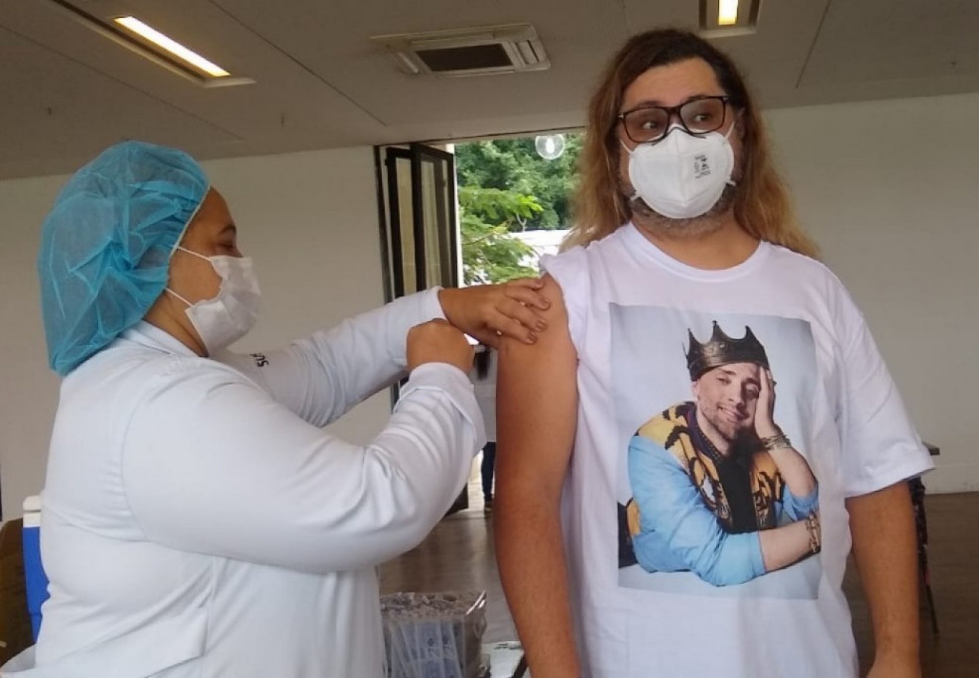 Marcus Majella recebe primeira dose da vacina contra a covid-19 usando camisa estampada com a foto de Paulo Gustavo - Ag. News