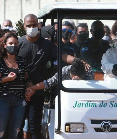 Enterro do sargento Alexandre Nogueira atingido por tiros na Avenida Brasil. Cemitério Jardim Saudade em Sulacap. Na foto a filha (de camisa preta e branca e calça preta) e a esposa (blusa preta com listras brancas).