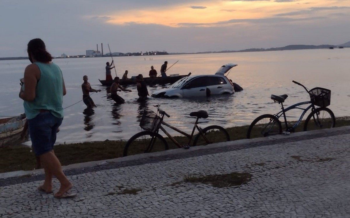 Carro foi para dentro do canal depois do motorista se atrapalhar e perder o controle. Pescadores ajudaram no socorro 